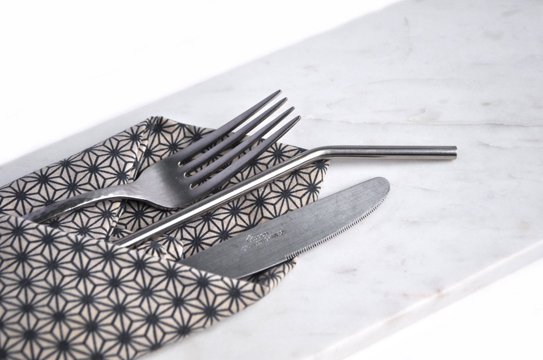 Image of Silverware, a patterned napkin and a marble cheese board