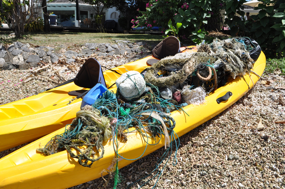 Image of a yellow kayak filled with ocean garbage