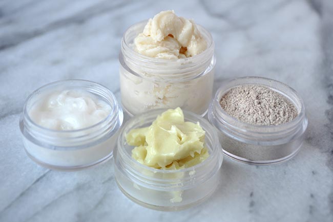Image of four plastic containers Travel Sized Containers containing deodorant cream, face wash, skin cream, and tooth powder